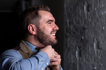 groom looking in mirror and touching bowtie