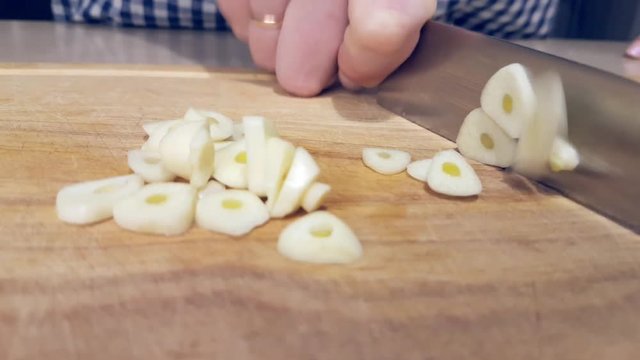 female chef cuts garlic for cooking vegetarian dishes, healthy food
