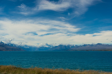 Lake Pukaki view from Glentanner Park Centre near Mount Cook, on a background of blue sky with clouds, snowy Southern Alps