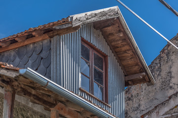 Detailed view of old and rustic house, with roof cock loft on roof