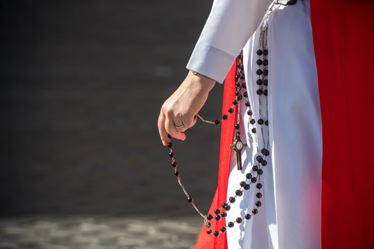 Vatican City, May 17, 2017: A nun from Sister of perpetual adoration praying the rosary walking.