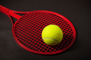 yellow tennis ball and red racket