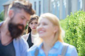 Really jealous of him. Jealous woman look at couple in love on street. Romantic couple of man and woman dating. Bearded man cheating his girlfriend with another woman. Unhappy girl feeling jealous