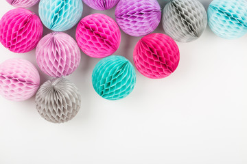 Honeycomb balls decorations background. Pink, lilac and turquoise paper pom pom. Flat lay. Holiday concept