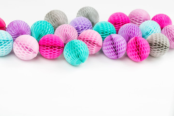 Fototapeta na wymiar Honeycomb balls decorations background. Pink, lilac and turquoise paper pom pom. Flat lay. Holiday concept