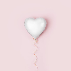 Single Balloon of heart shaped foil on pastel pink background. Love concept. Holiday celebration. Valentine's Day or wedding/bachelorette party decoration. Metallic balloon