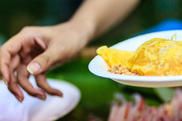 Close up hand of vendor during cooking for the original Thai Fried Noodle(Pad Mee Boran), stir-fried noodle with shrimp and egg commonly served as a street food popular in Thailand