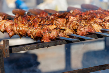 Grilled kebab cooking on metal skewer. Roasted meat cooked at barbecue