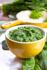 Healthy vegetarian or vegan food, cooked green spinach with cream, ingredient for many dishes like pasta, ravioli or soup