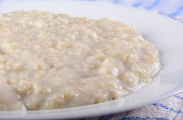 Healthy oatmeal closeup on a white plate