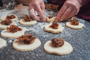 Woman making homemade Hamantaschen cookies using fresh ingredients