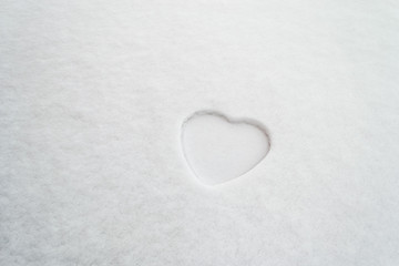 Symbol of a white heart painted on snow. Romance concept for Saint Valentine's day, Mother's Day or Women's Day.