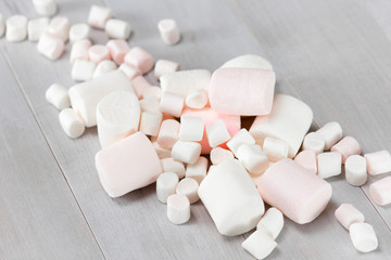 Fototapeta na wymiar Various white marshmallows on the grey wooden table.