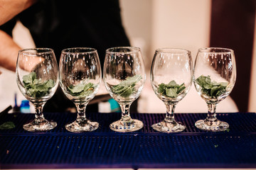 preparing of refreshment cocktail with mint and ice. Mojito drink served at bar, pub or restaurant