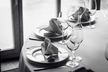 Tables set for an event party or wedding reception. Glasses and dishes.