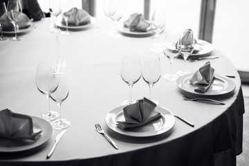 Tables set for an event party or wedding reception. Glasses and dishes.