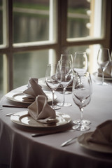Tables set for an event party or wedding reception. Glasses and dishes.