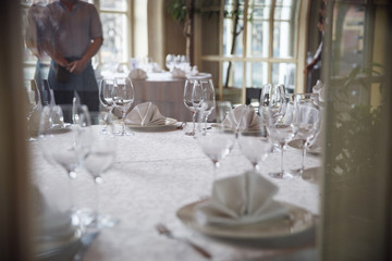 Tables set for an event party or wedding reception. Glasses and dishes.