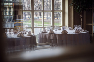 Tables set for an event party or wedding reception. Glasses and dishes.