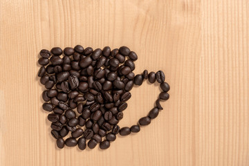 Coffee cup made from beans on wooden floor.
