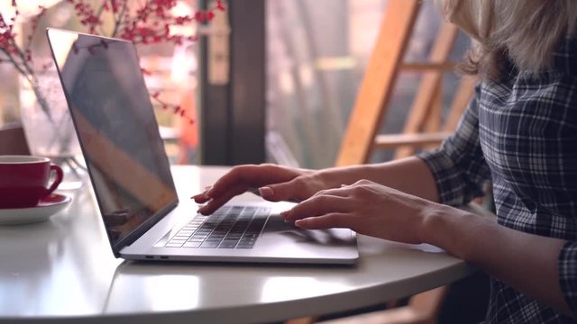 Closeup woman work out of the office. Sitting table notebook female hands keyboarding laptop using texting pointing networking