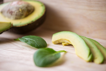 Close-up of a fresh juicy green ripe avocado on wooden table. Healthy food