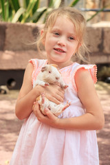 little girl hugging guinea pig in her arms