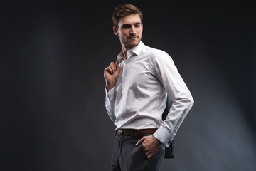 Portrait of a handsome young businessman dressed in suit isolated over gray background.