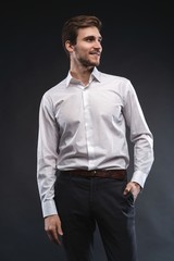 Fototapeta premium Portrait of a handsome young businessman dressed in suit isolated over gray background.