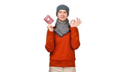 The Caucasian man with the international passport of the Russian Federation in warm clothes. Gesture OK, everything is good