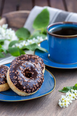 Chocolate donuts and cups of tea