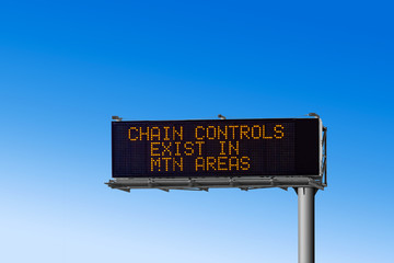Highway electronic road sign - Chain Controls Exist in MTN Areas - with blue background