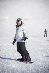 Fototapeta na wymiar Young guy snowboarder having fun in the winter ski resort .