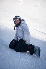 Fototapeta na wymiar Young guy snowboarder having fun in the winter ski resort .