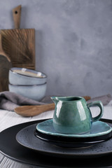 Collection of  natural  rustic  handmade crockery tableware in neutral tones on grey background