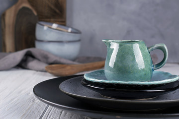 Collection of  natural  rustic  handmade crockery tableware in neutral tones on grey background