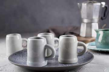 Set of grey rustic coffee cup handcraft and geyser coffee maker against shabby grey wall. Natural  handmade crockery tableware