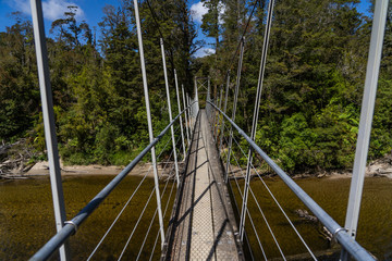 Fototapeta premium long bridge at Pororari River track, landscape on the Pororari River Track, new zealand, south island, Wild New Zealand forest or jungle, Catlins, South Island. 