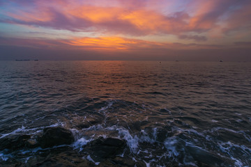 朝焼け雲と足元に寄せる波