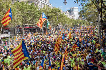 People wave 'Esteladas' (pro-independence Catalan flags) as they gather during a pro-independence...