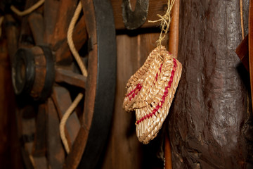 old bast slippers hang on the background of the old wheel