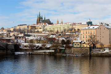 Obraz premium Snowy Prague Lesser Town with Prague Castle above River Vltava in the sunny Day, Czech republic
