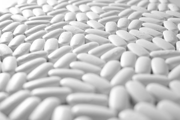 Macro close-up of many white pills, medication concept