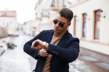 Stylish young businessman in an elegant coat in trendy sunglasses with a stylish hairstyle in a...