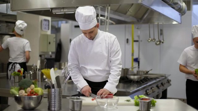 chef preparing salad cooks helping
