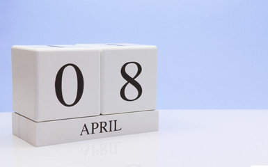 April 08st. Day 08 of month, daily calendar on white table with reflection, with light blue background. Spring time, empty space for text
