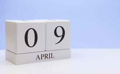 April 09st. Day 09 of month, daily calendar on white table with reflection, with light blue background. Spring time, empty space for text