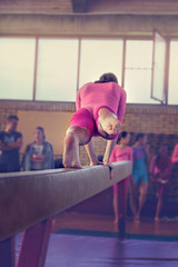 Young girl athlete gymnast on balance beam competition in gymnastics. Focus on feet - Image