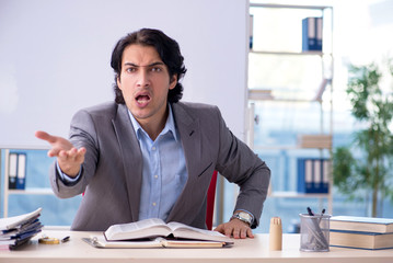 Young handsome teacher in front of whiteboard