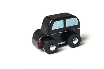 closeup of miniature wooden car on white background - concept british taxi